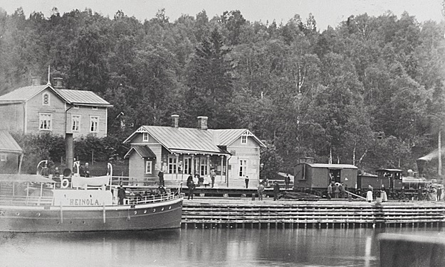 Rautatieasema Vesijärven rannalla. Etualalla järvi sekä laivoja.